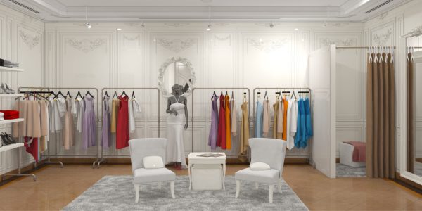 Elegant white boutique interior with ornate walls, racks of colorful dresses, and a white gown on a mannequin center stage.