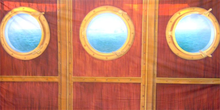 Wooden ship wall with three round portholes showing blue ocean.