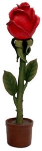 Red rose in a small brown pot with green stem and leaves against a white background.