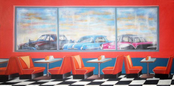Diner interior with red walls, orange booths, and a three-panel mural of vintage cars above the tables; black-and-white checkered floor.