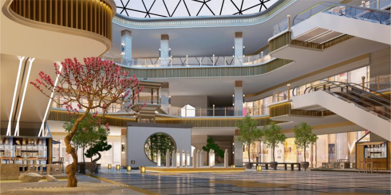 Modern shopping mall atrium with curved balconies, escalators, skylight, and planted trees.