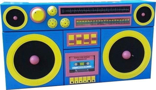 Bright blue toy boombox with yellow speaker rings and pink accents, resembling a retro stereo for kids.
