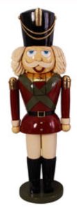 Wooden nutcracker soldier figurine in a red uniform with a tall black hat, gold trim, and a round base.